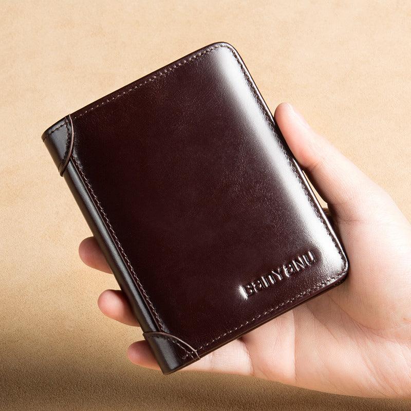 Billetera de cuero genuino color café oscuro para hombre, sostenida en la mano.